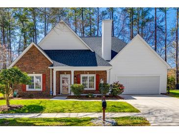 Charming brick home with a manicured lawn, white trim, and a two-car garage at 7124 Bevington Woods Ln, Charlotte, NC 28277