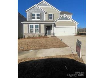 Charming two-story home featuring a two-car garage and neutral-colored siding with stone accents at 121 Goorawing Ln, Mooresville, NC 28115
