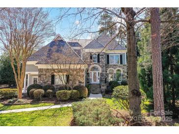 Stunning stone exterior with well-manicured landscaping, and a charming entrance, creating an inviting curb appeal at 18512 Square Sail Rd, Cornelius, NC 28031