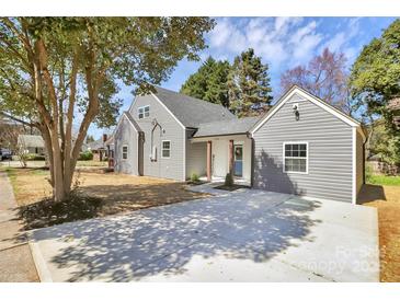 Well-maintained home with gray siding, mature trees, and a spacious driveway at 244 N Race St, Statesville, NC 28677