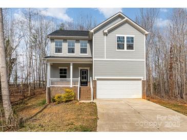 Charming two-story home featuring gray siding, front porch with white railing, and an attached two-car garage at 418 Wintergreen Ct, Kings Mountain, NC 28086