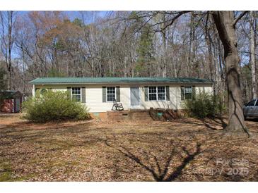 Charming single-story home featuring a brick foundation and front porch, nestled among mature trees at 7597 Webbs Rd, Denver, NC 28037