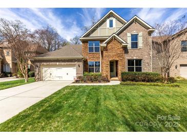 Charming brick home featuring a lush lawn and a two-car garage and a beautifully landscaped front yard at 110 Kingsdown Ave, Charlotte, NC 28270