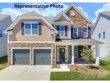 Charming two-story home featuring a two-car garage and a welcoming front porch at 121 Asmodean Ln, Troutman, NC 28166