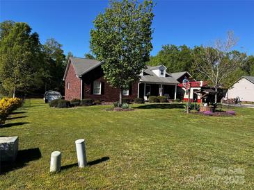 Charming brick home featuring a well-manicured lawn and mature trees, creating a welcoming curb appeal at 1280 Weatherby Dr, Salisbury, NC 28146