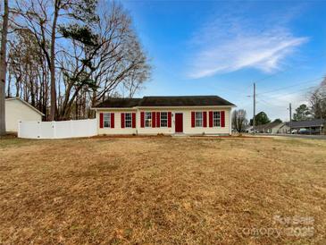 Inviting single-story home featuring red shutters and a well-maintained front lawn at 1313 Ridgewood Dr, Concord, NC 28027