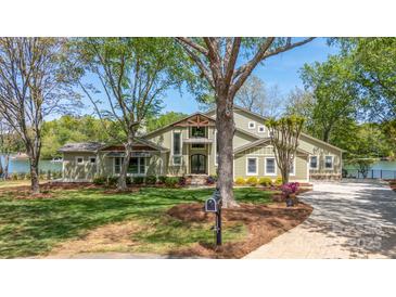 Stunning two-story home boasts a beautiful lawn, mature trees, and a charming front entrance on a sunny day at 19528 Mary Ardrey Cir, Cornelius, NC 28031