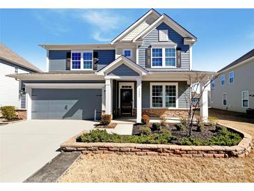 Beautiful two-story home featuring a two-car garage, well-maintained lawn, and stylish blue siding at 2085 Saddlebred Dr, Iron Station, NC 28080