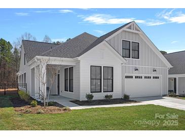 Beautiful home with white siding, black trim windows, well-manicured lawn, and attached two car garage at 218 Alenda Lux Cir, Mooresville, NC 28115