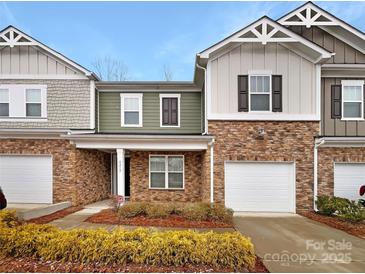 Charming townhome with a brick facade, attached garage, and manicured landscaping, offering great curb appeal at 8212 Merryvale Ln, Charlotte, NC 28214