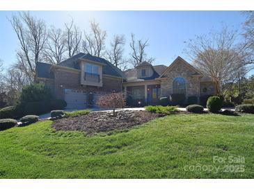 Beautiful stone and brick home featuring a manicured lawn and mature landscaping for great curb appeal at 13008 Ginovanni Way, Mint Hill, NC 28227