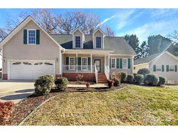Charming home featuring a manicured lawn, dormer windows, shutters and a inviting covered front porch at 1442 Rainforest Ct, Gastonia, NC 28054