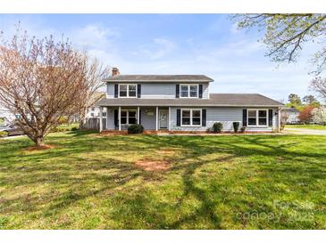 Charming two-story home with a well-maintained lawn, beautiful tree, and inviting front porch at 1448 Morrocroft Trl, Gastonia, NC 28054