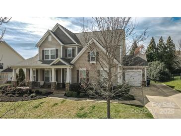 Charming two-story home featuring a covered porch, well-manicured lawn, and attached two-car garage at 15125 Skypark Dr, Huntersville, NC 28078