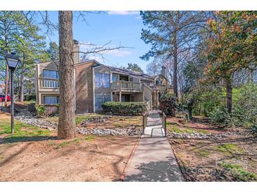 Charming condo exterior with brick accents, a front patio, and mature trees on a sunny day at 1606 Sharon W Rd, Charlotte, NC 28210