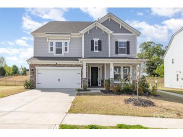 Charming two-story home featuring a two-car garage, stone accents, and a well-maintained front yard at 165 Winterberry St, Mooresville, NC 28117