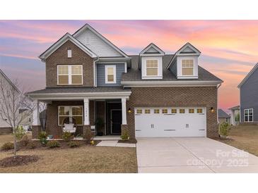 Charming brick home with a two-car garage and covered front porch at 1854 Carrollton Dr, Indian Trail, NC 28079