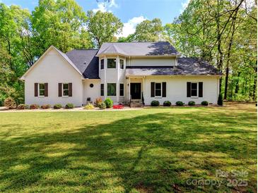 Charming two-story home with a well-manicured lawn and complemented by mature trees that offer shade and privacy at 207 Windsor Greene Dr, Monroe, NC 28110