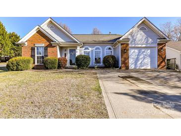 Charming single-story home featuring brick accents, light siding, manicured bushes and a well maintained lawn at 4137 Whitney Nw Pl, Concord, NC 28027