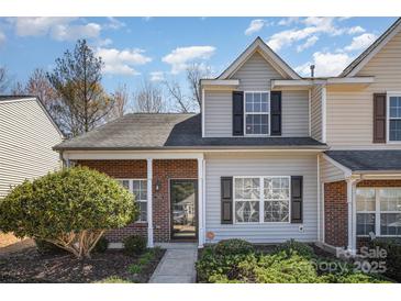 Charming townhome featuring a brick facade, well-manicured landscaping, and inviting entrance at 7361 Sun Dance Dr, Fort Mill, SC 29707