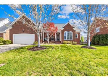 Charming brick home boasts a well-manicured lawn, attached garage, and inviting front porch at 127 Oxford Dr, Mooresville, NC 28115