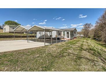 Cozy home featuring dual carport parking, with green lawn space and blue sky backdrop at 4285 Dc Dr, Concord, NC 28025