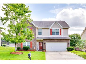 Charming two-story home featuring brick accents, red shutters, well-manicured lawn, and attached two-car garage at 10071 Highland Creek Cir, Indian Land, SC 29707