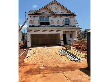 New construction home with a two-car garage and visible framing at 5704 Skinny Dr, Charlotte, NC 28215