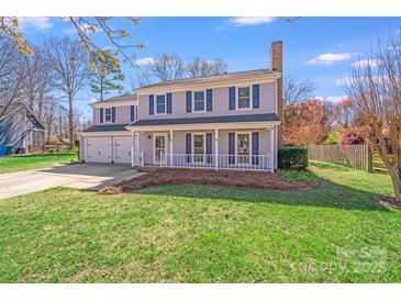 Charming two-story home with a front porch, blue shutters, and a well-maintained lawn at 13732 Strathaven Dr, Matthews, NC 28105