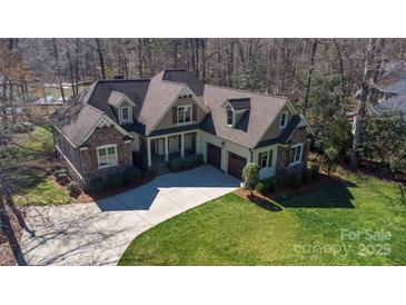 Aerial view of the stunning home featuring a stone facade, beautiful landscaping, and a long driveway at 147 Pearl Bay Dr, New London, NC 28127