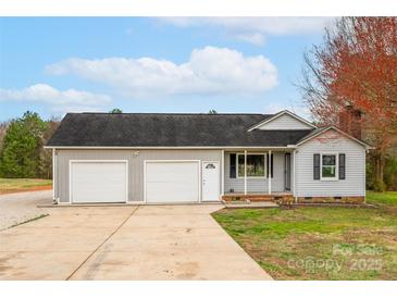 Charming home featuring a two-car garage and a well-maintained front yard with mature trees at 155 Country Ln, Mooresville, NC 28115