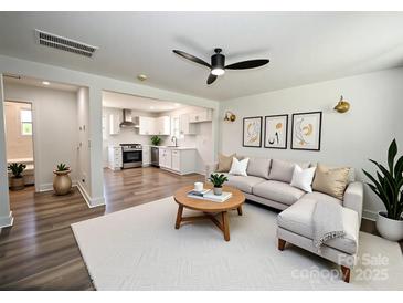 Bright living room featuring a modern ceiling fan, neutral color palette and an open floor plan to the kitchen at 621 Cauthen St, Rock Hill, SC 29730