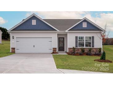 Charming single-story home showcasing blue gable accents, a two-car garage, and manicured landscaping at 7128 Jerimoth Ln, Charlotte, NC 28215