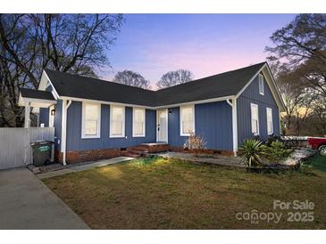 Charming single-story home with a blue exterior, well-maintained lawn, and inviting front entrance at 9418 Stately Oak Ln, Mint Hill, NC 28227