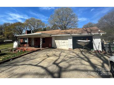 Charming single-story home featuring a brick facade, attached garage, and covered porch at 1632 Browns Ave, Charlotte, NC 28208