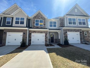 Charming townhome with a two-car garage, stone accents, and neutral color palette at 6275 Tea Olive Dr # 176, Harrisburg, NC 28075