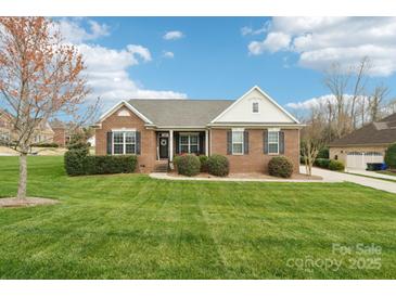 Charming brick home with a lush green lawn, manicured bushes, and a welcoming front entrance with black shutters at 205 Cowboys Cir, Rock Hill, SC 29732