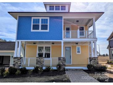 Charming two-story home with blue and yellow siding, inviting front porch, and stone accents at 255 Luray Way # 442, Rock Hill, SC 29730