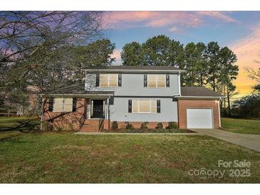 Charming two-story home boasts brick and vinyl siding, and a well-manicured lawn at 2611 Rolling Hills Dr, Monroe, NC 28110