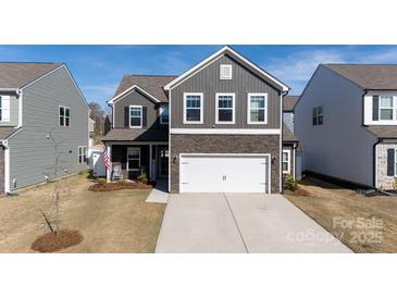 Two-story home features gray siding, stone accents, a two-car garage, and a well-maintained lawn at 446 Brannon Meadows Dr, York, SC 29745