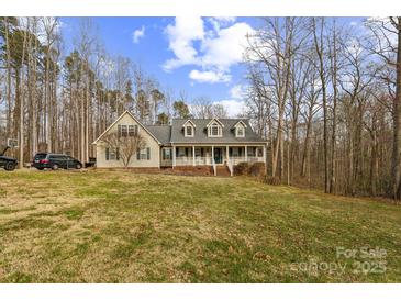 Charming home featuring a welcoming front porch and a well-manicured lawn under a blue sky at 9575 Old Concord Rd, China Grove, NC 28023