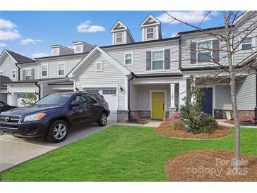 Charming two-story townhome with a well-manicured lawn and a bright yellow front door at 13024 Suncreek Ter, Charlotte, NC 28214