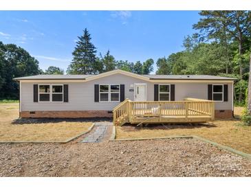 Charming single-story home with a light gray exterior and a newly built wooden porch and deck at 143 Lakewind Dr, Mooresville, NC 28115