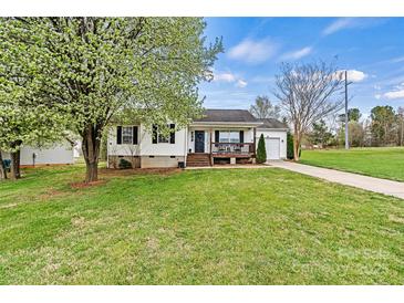 Charming home features a front porch and a lush green lawn, creating an inviting curb appeal at 301 N 4Th Ave, Maiden, NC 28650