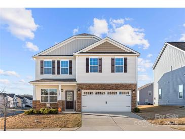 Charming two-story home featuring stone accents, a two-car garage, and a well-manicured front lawn at 9706 Tea Garden Dr, Gastonia, NC 28056