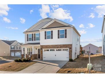 Inviting two-story home with stone details, two-car garage, and a lush front yard, perfect for families at 9706 Tea Garden Dr, Gastonia, NC 28056