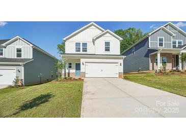 Charming two-story home boasts a well-maintained lawn, a two-car garage, and a welcoming blue front door at 138 Satchel Ct, Mooresville, NC 28115