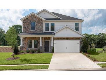 Two-story home featuring a two-car garage, stone facade, and manicured lawn at 142 Shepherds Landing Dr, Mooresville, NC 28115