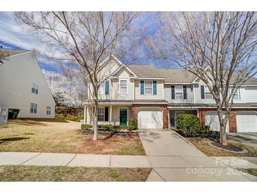 Townhome with light siding, brick facade, a green door, and attached garage at 16729 Timber Crossing Rd, Charlotte, NC 28213