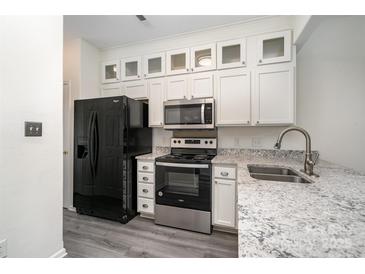 Updated kitchen with white cabinetry, stainless steel appliances, and granite countertops at 4028 Center Place Dr, Harrisburg, NC 28075